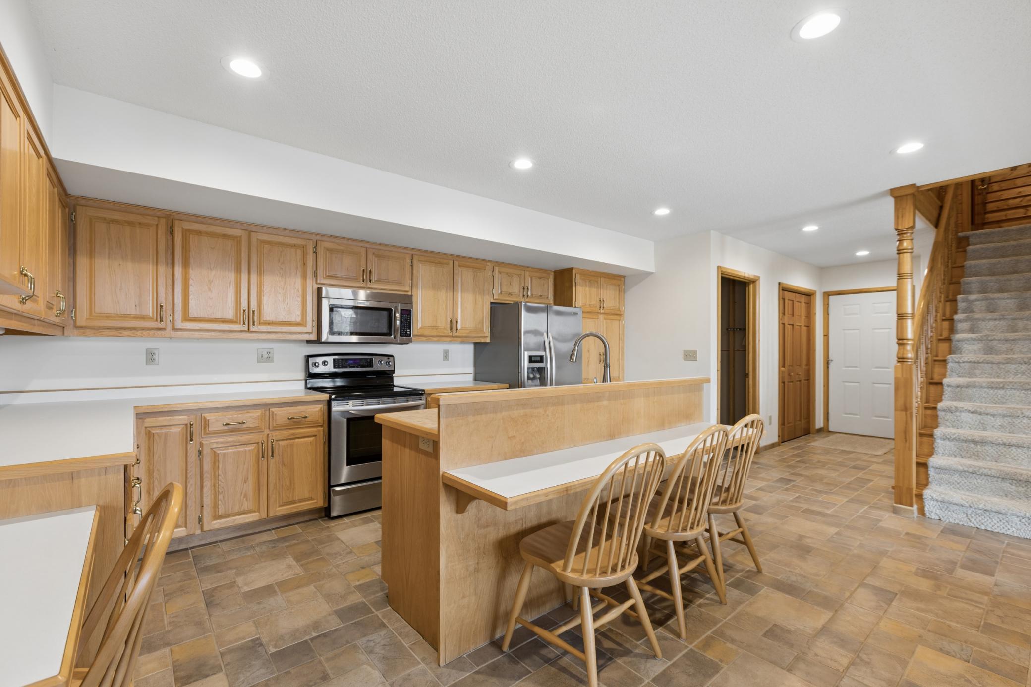 Just past the kitchen is a storage room, two large closets as well as a stairwell offering direct access to the attached garage from the lower level.