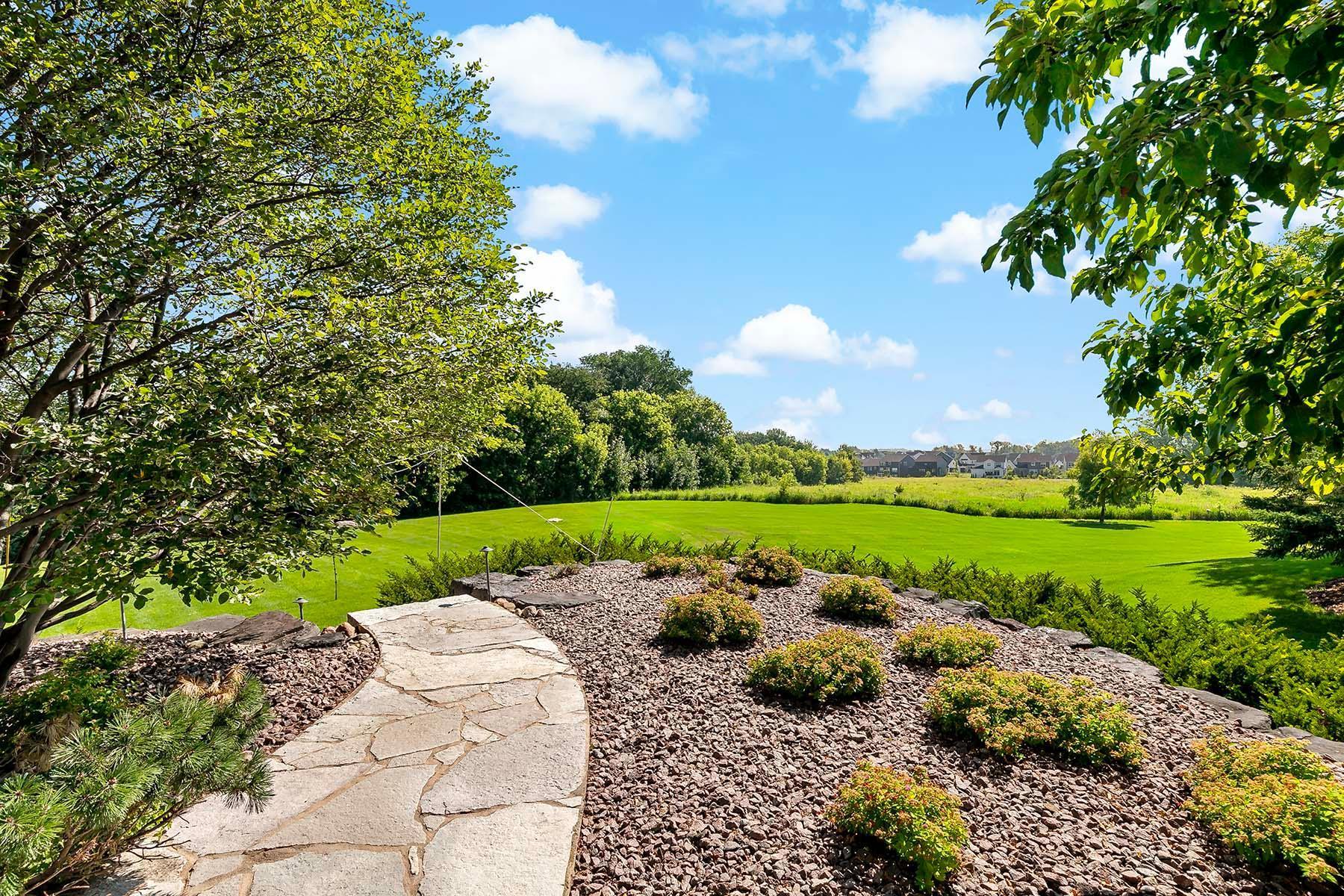 The professionally designed landscaping enhances the beauty of the home in every season, with thoughtfully placed plantings, stonework, and lighting that create a truly stunning and serene outdoor environment.