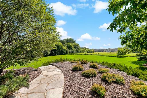 The professionally designed landscaping enhances the beauty of the home in every season, with thoughtfully placed plantings, stonework, and lighting that create a truly stunning and serene outdoor environment.