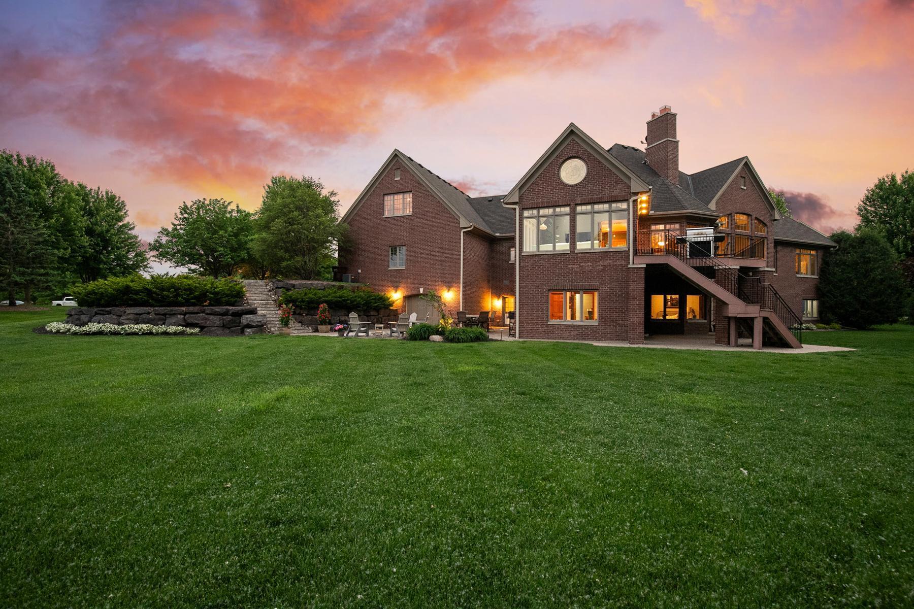 At night, the home comes alive with elegant uplighting that highlights the architectural lines and all-brick exterior, creating a warm and welcoming glow.