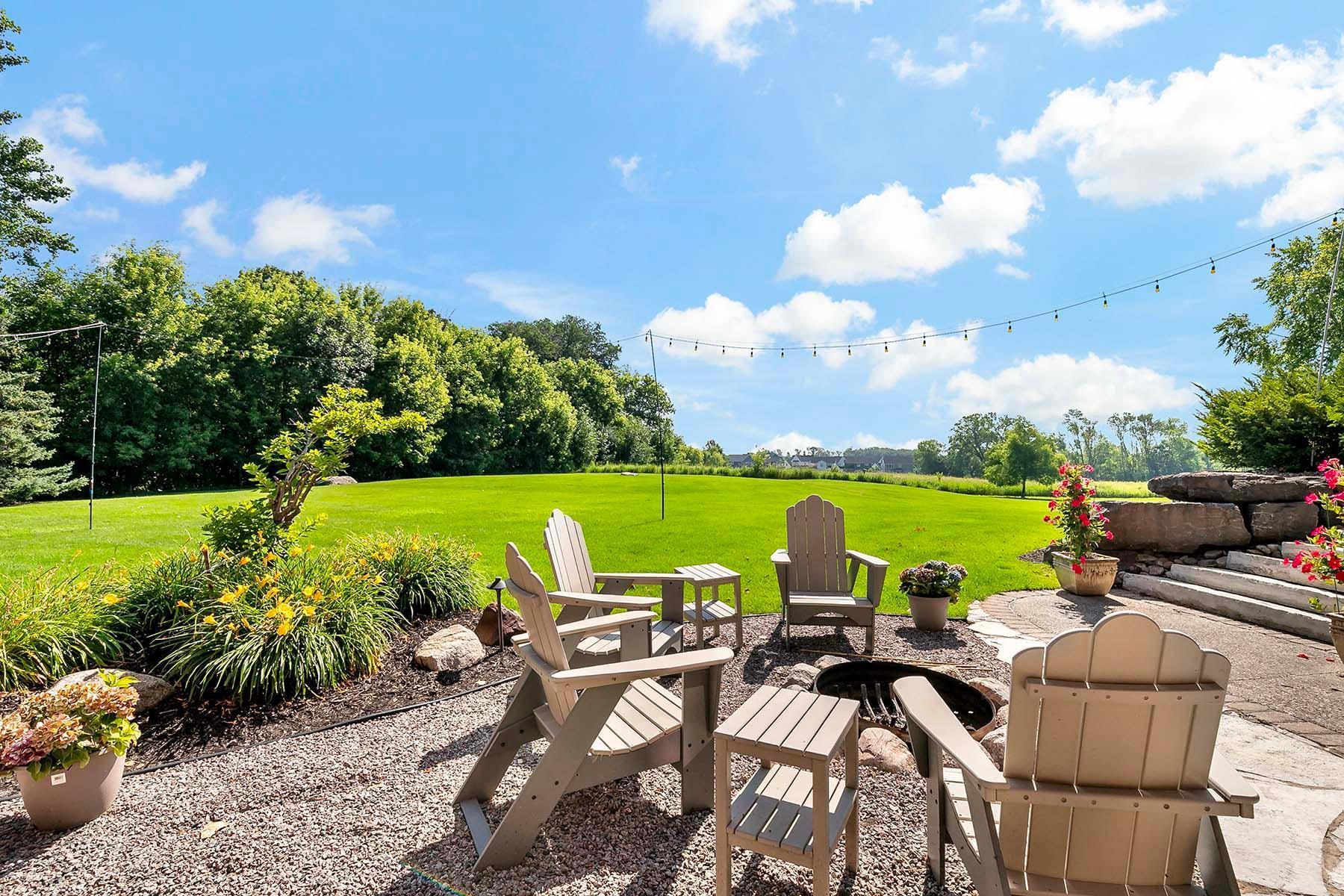 The backyard is perfectly designed for outdoor entertaining, featuring multiple gathering areas and a built-in fire pit that invites cozy evenings under the stars with family and friends.