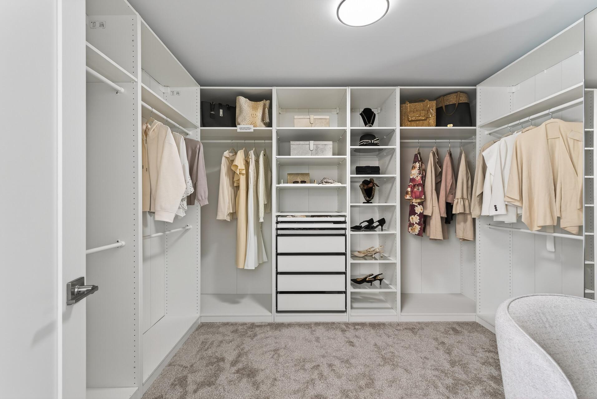 Custom walk-in closet with mirrored glass doors, pull-out drawers, and a mix of hanging and shelf space