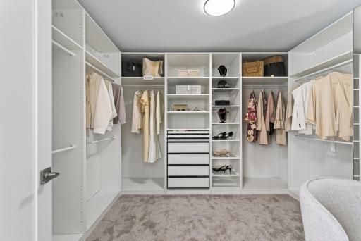 Custom walk-in closet with mirrored glass doors, pull-out drawers, and a mix of hanging and shelf space