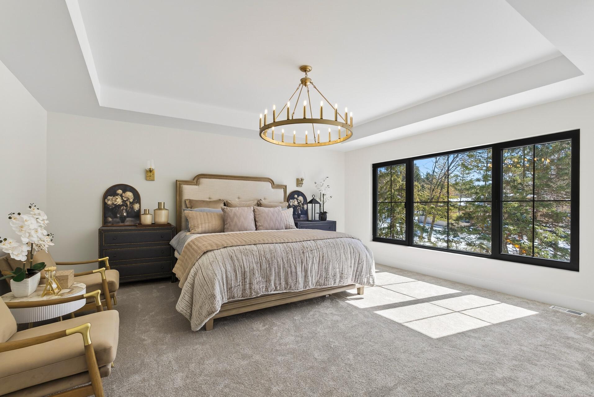 Primary suite with oversized windows offering stunning year-round views and lots of natural light