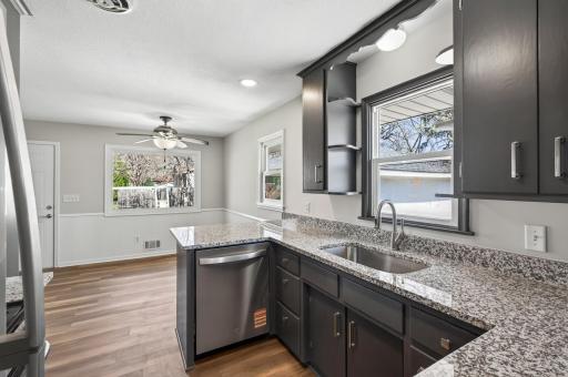 The kitchen features dark, moody cabinetry paired with sleek hard surface countertops and updated hardware.