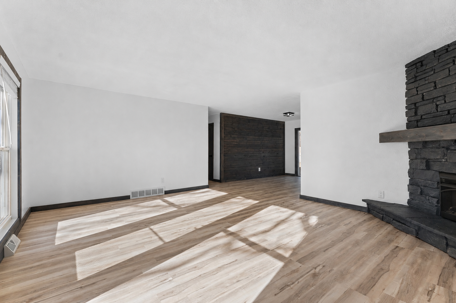 Large windows throughout the main level fill the home with abundant natural light while showcasing beautiful views of the mature surrounding trees.