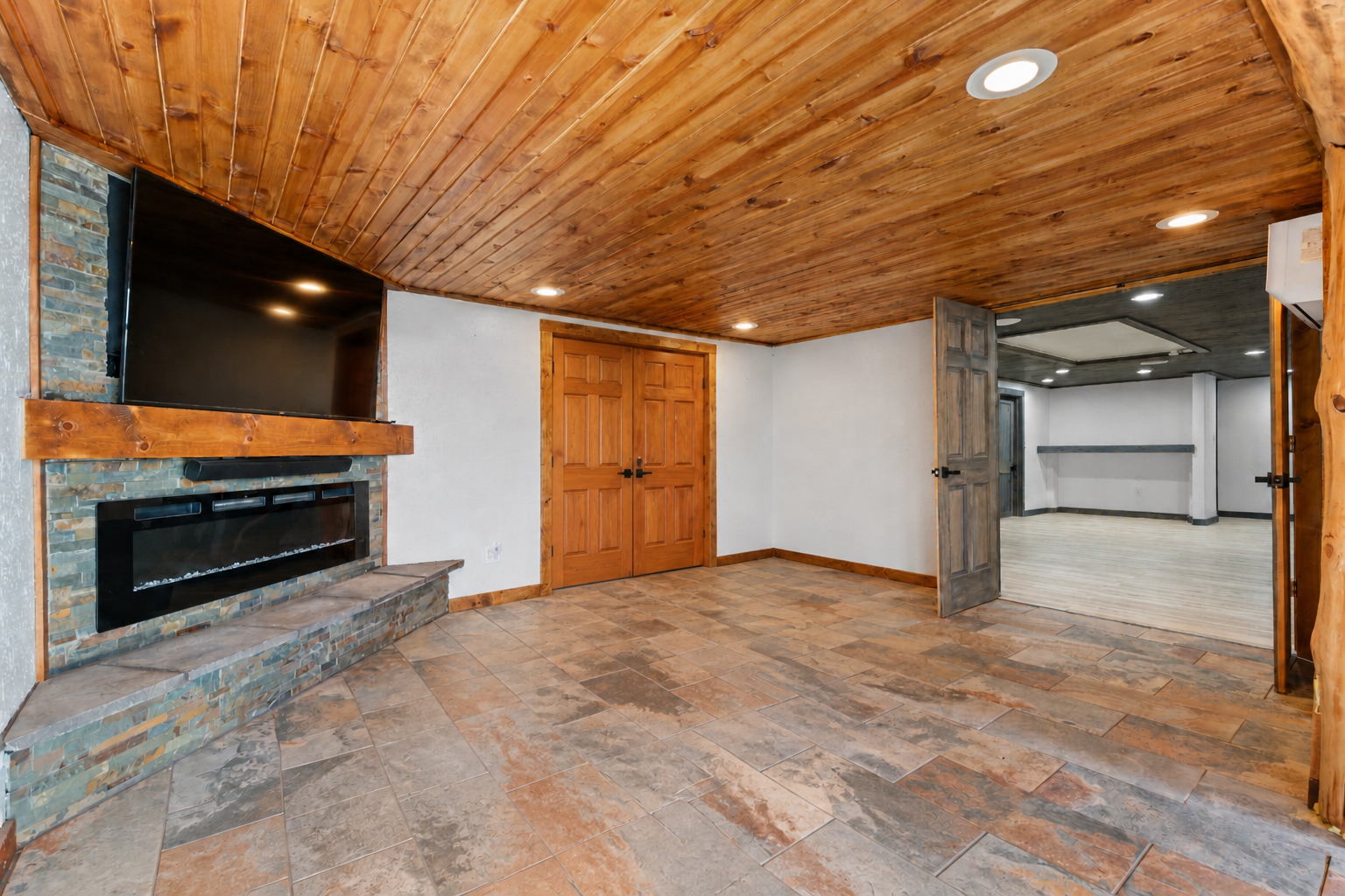 The versatile fourth bedroom works perfectly as a primary suite, a spot for older kids, a private guest space, or an extra lounge space. Complete with an electric fireplace and beautiful wood accents!