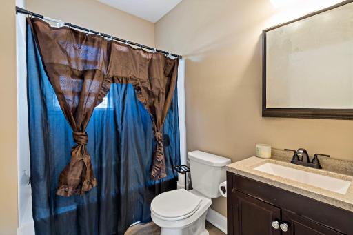 This bright and functional full bath features a vanity with built-in storage and a window that brings in natural light, creating a clean and comfortable space for everyday use.