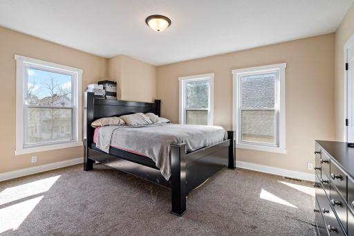 Located on the upper level, this spacious primary bedroom offers generous room to relax, with both east & south facing windows filling the space with natural light.