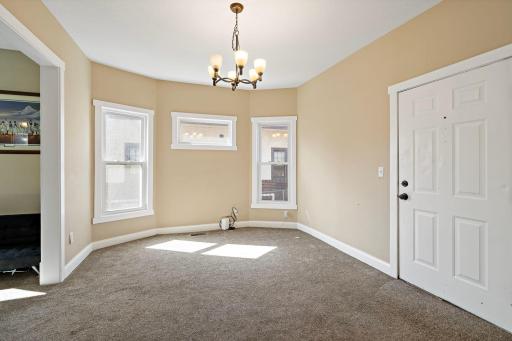 Dining area/room featuring a bay wall with windows and a chandelier.