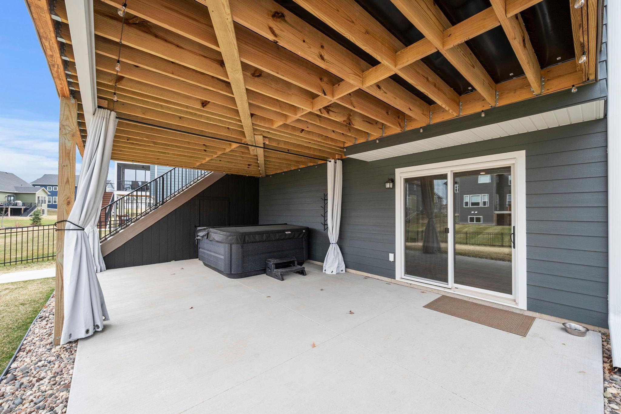 Patio space under the deck with privacy wall for potential Hot Tub.