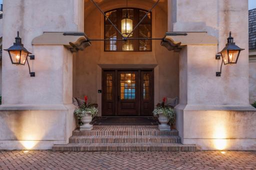 The grand archways with gas lanterns welcome you into French Country Charm.