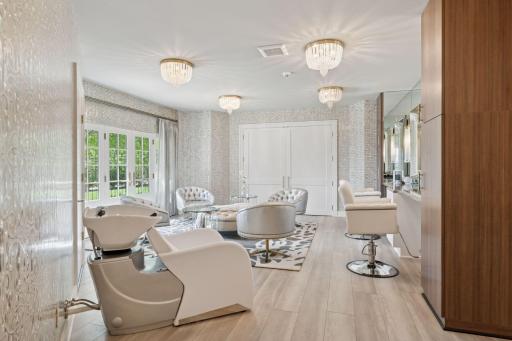 The salon area is a luxurious retreat and the perfect space for pampering! Featuring a washing station, a cozy sitting area, and dressing room. This salon seamlessly opens up to the outdoor pool area.