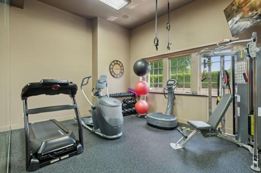 A separate gym area overlooks the court, creating an inspiring workout space. Large windows allow natural light to flood in, enhancing motivation and making exercise enjoyable.