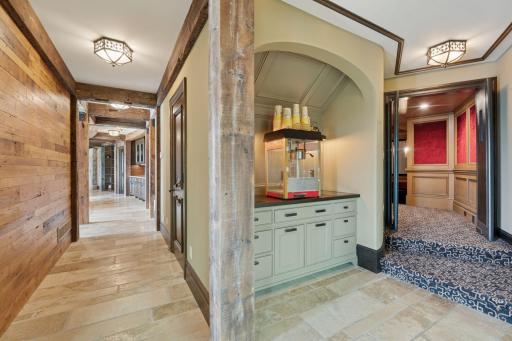 As you head a little further down, you’ll arrive at the impressive theater room! A dedicated popcorn station adds a fun and nostalgic touch, equipped with a popcorn machine and storage for snacks, making it easy to indulge in classic movie treats.