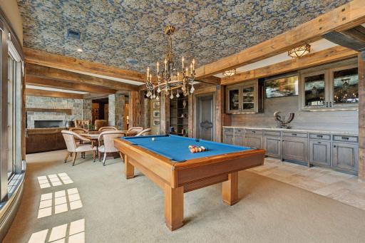 A well-appointed wet bar makes entertaining a breeze, complete with stylish countertops, seating area, and pool table!
