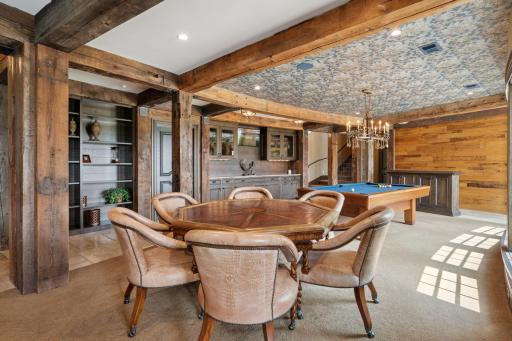 The lower level exudes true rustic charm, featuring exposed beams that add character and warmth to the space. The design embraces natural materials, creating an inviting atmosphere that feels both cozy and sophisticated.