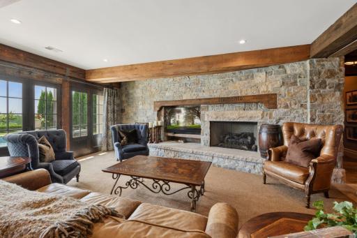 The family room features a stunning floor-to-ceiling stone fireplace that serves as a striking focal point. Large doors open directly to the backyard. This transition allows tons of natural light to flood the room.