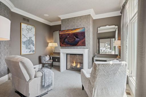 Off the primary is a cozy sitting room, complete with its own fireplace, creating a perfect nook for relaxation, whether you're enjoying a morning coffee or winding down in the evening.