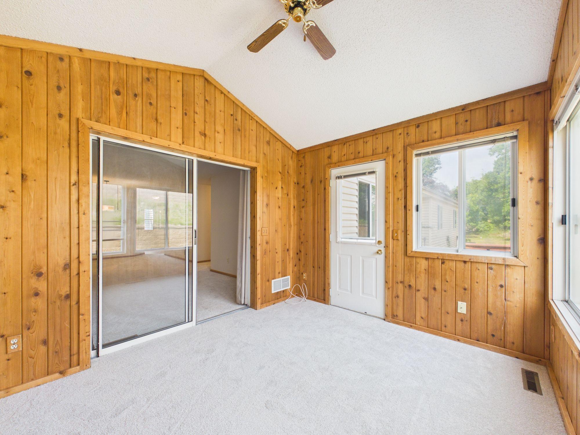 Vaulted ceiling and wraparound windows in the knotty pine sunroom, true condition, no staging