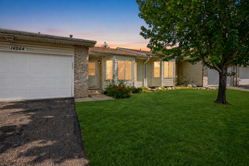 Photo for 14264 Glencove Path, Saint Paul, MN 55124 - listing #7051247 Twilight exterior view of the one-level Apple Valley townhome with attached 2-car garage, covered front entry, mature tree, and landscaped front yard.