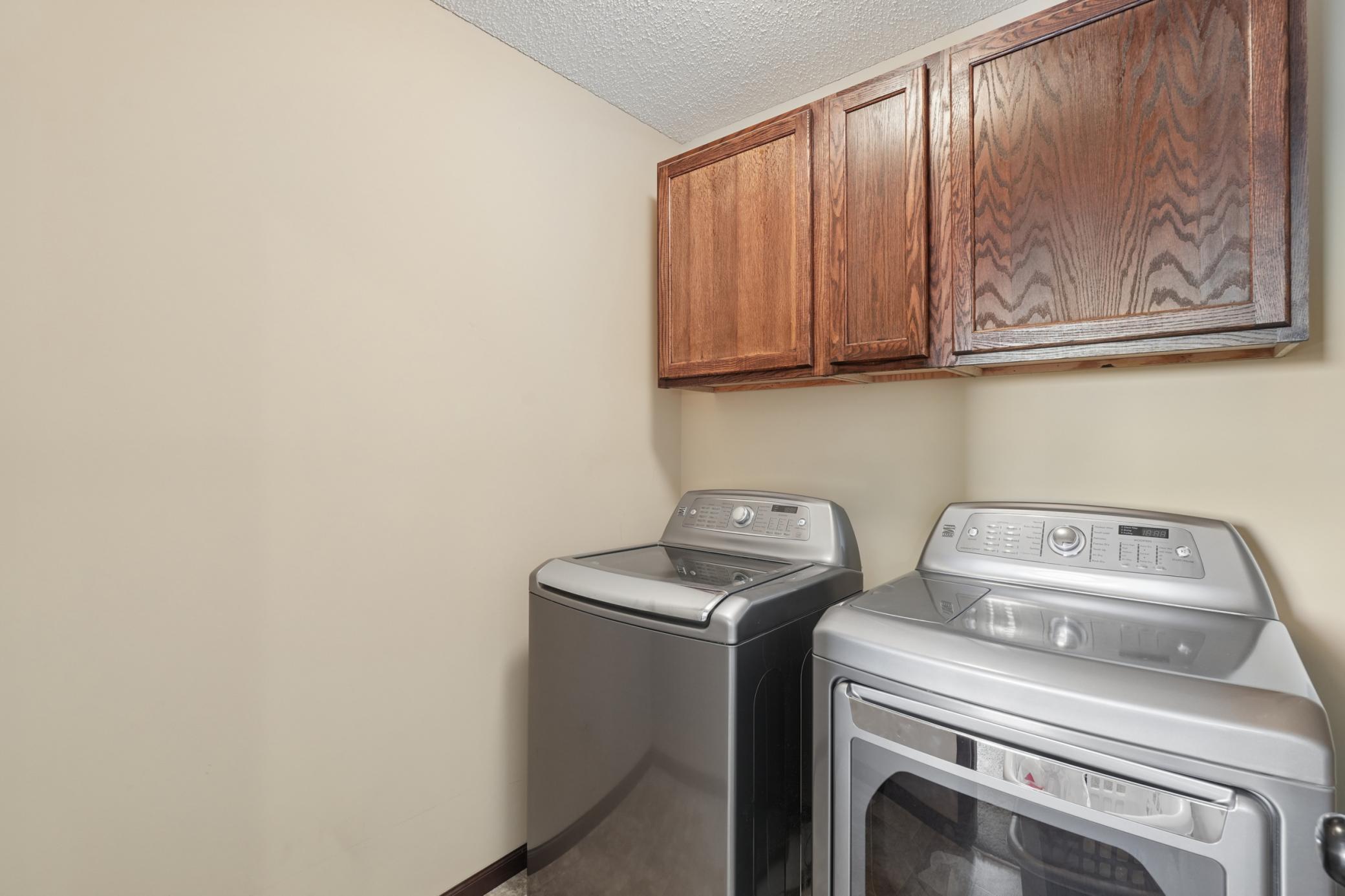 Convenient upper-level laundry room with storage cabinets
