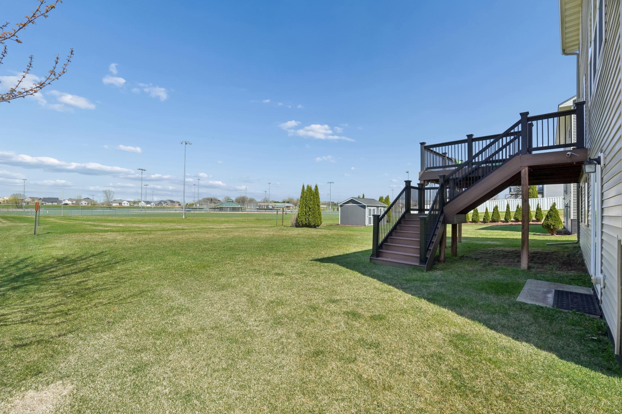 Spacious backyard connected to the park and ball fields provides ample space to enjoy outdoor games and recreation.