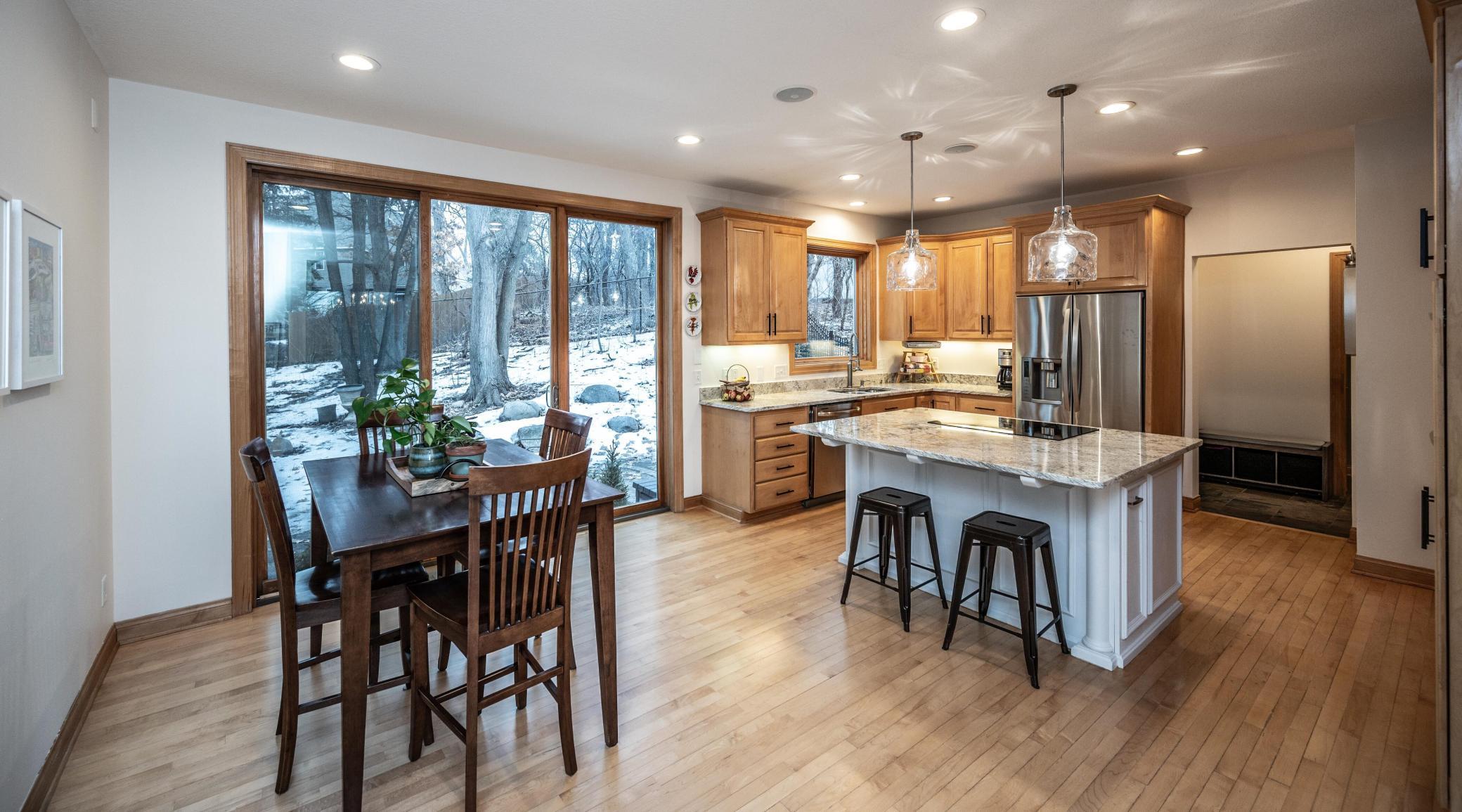 Triple sliding glass doors in informal dining and kitchen are impressive which leads to the paver patio area and private yard.