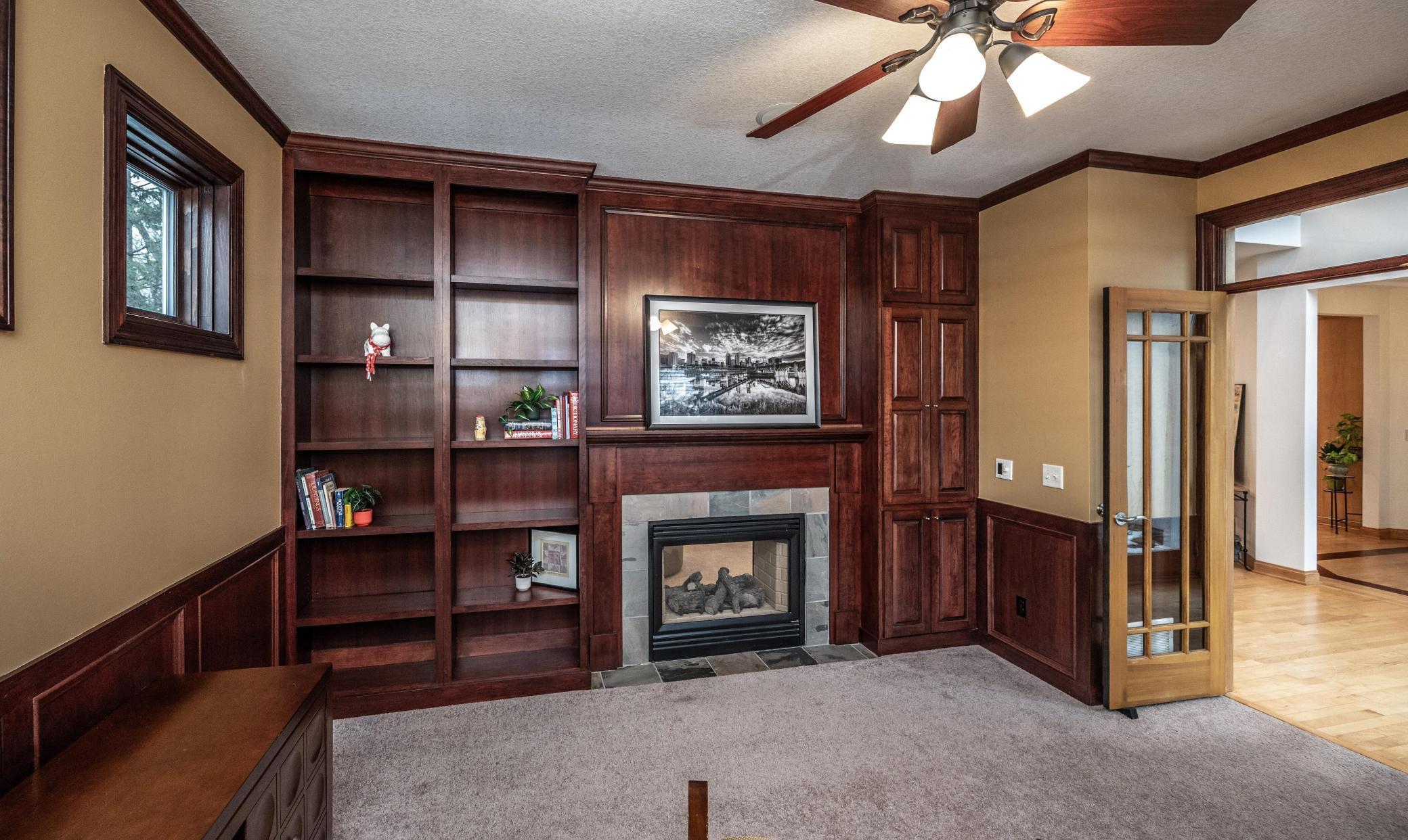 Handsome main floor den or office (or could be a formal living room) to the front of the home, built-in shelves and a warm 2-sided gas fireplace.