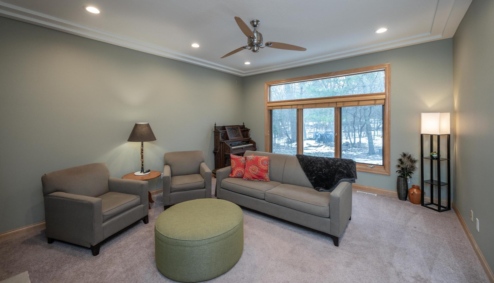 Triple windows topped with a transom overlook the backyard.
