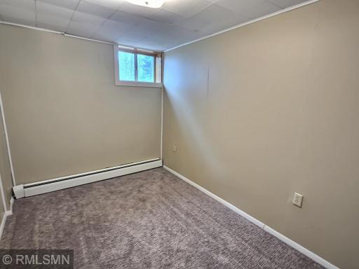 The final room in the lower-level includes carpet floors, neutral colors, and baseboard heat.