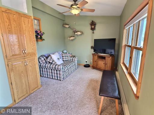 The cozy sitting area off of the dining room features carpet floors, great views of the backyard and storage cabinets.
