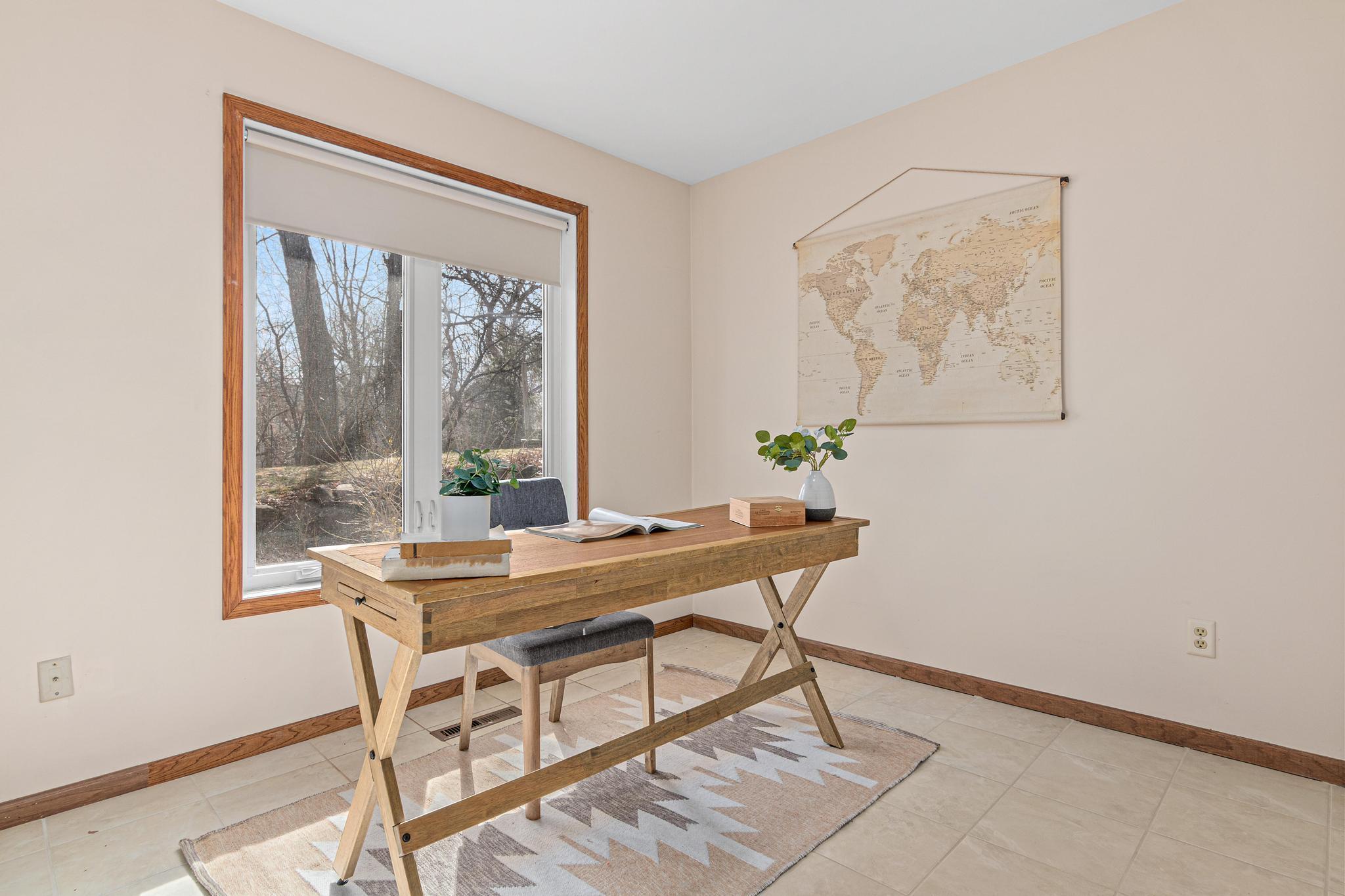 Third bedroom - staged as an office space. Large window and tiled floors.