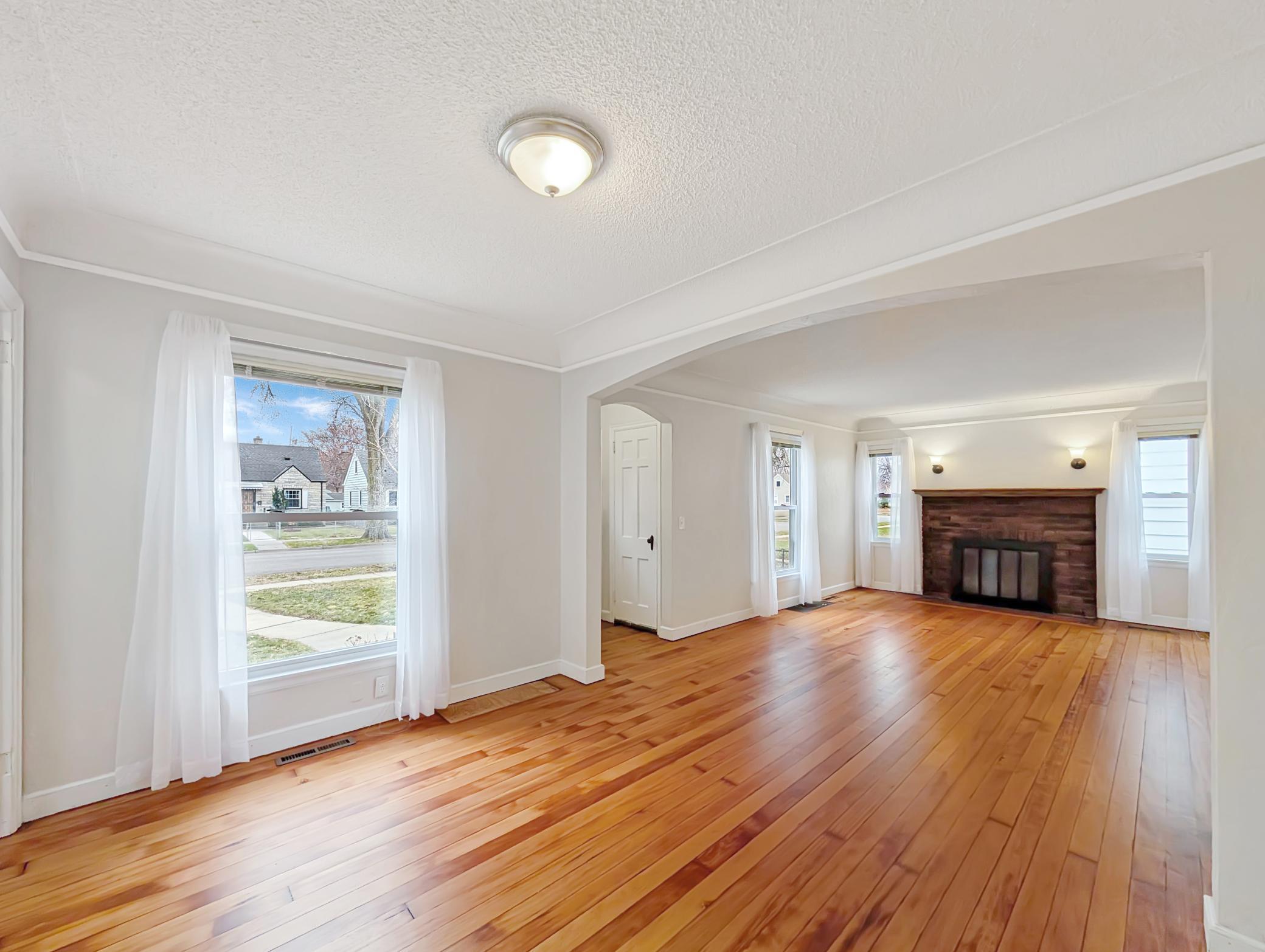 This cozy living room is lit up by large windows and features a fireplace for warmth and style!