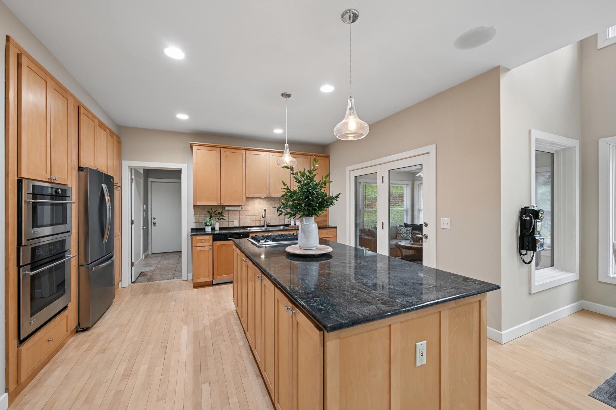 Large kitchen with oversized island, double ovens, new fridge, and cooktop.