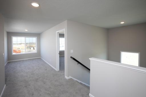 PHOTO OF A DIFFERENT HOME WITH SIMILAR PLAN. FINISHES MAY VARY. Upper Level Hallway View to Staircase and Versatile Loft area.