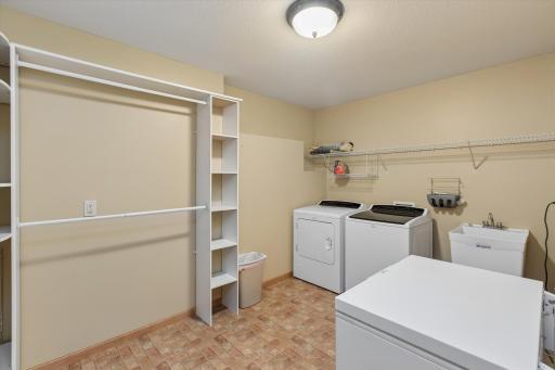Lower-level laundry room with convenient shelving and utility sink