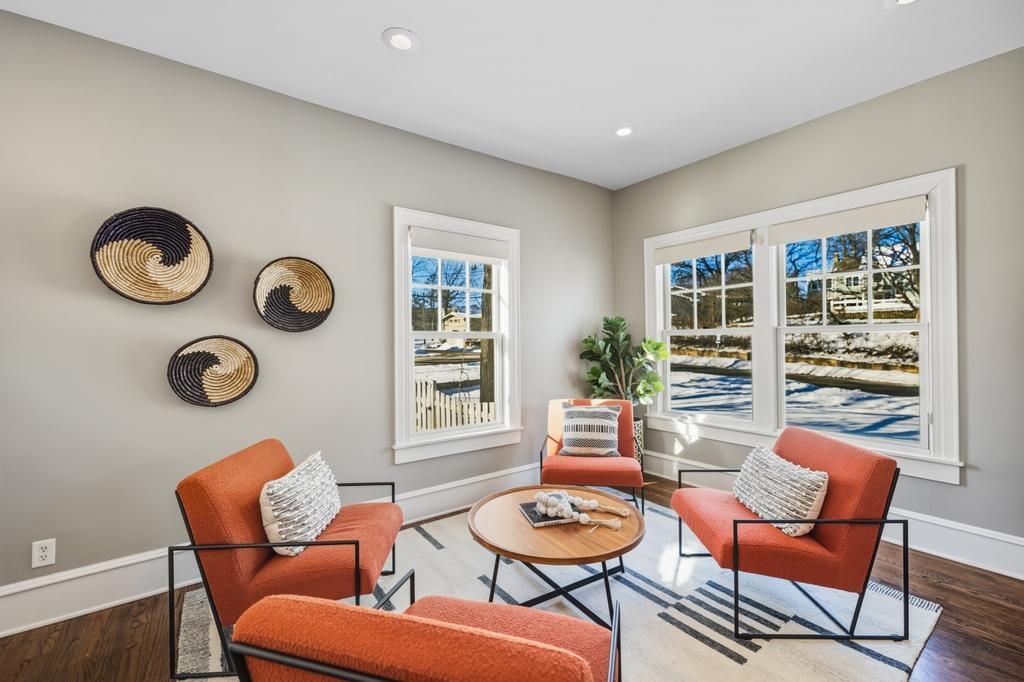 At the opposite end of the living room, this sun-filled sitting area framed by windows, offers a quieter place to unwind.