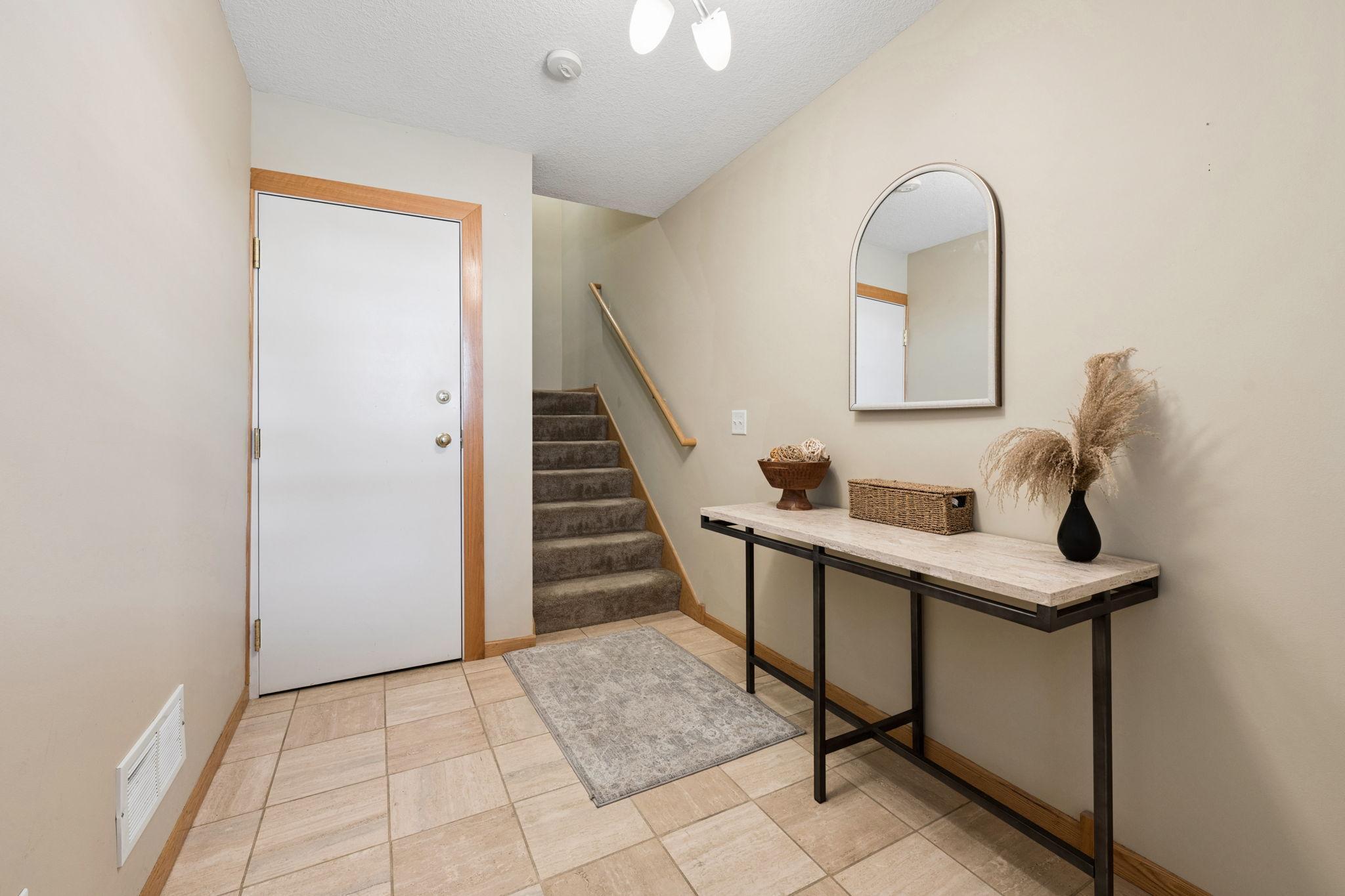Welcoming entry with tile flooring and a functional layout leading to the main living areas. Convenient access to upper level and additional storage.