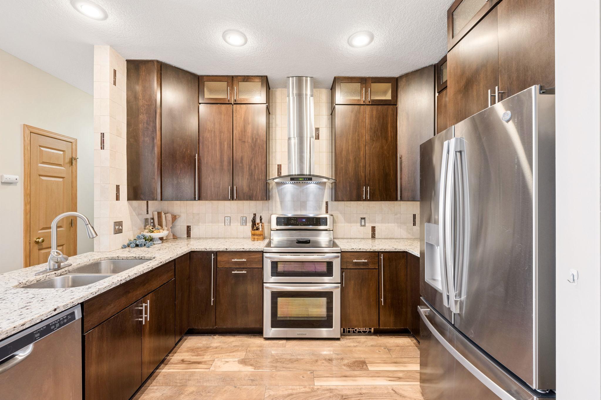 Stylish kitchen featuring granite countertops, stainless steel appliances, and custom cabinetry. Thoughtful layout offers both function and ample storage.