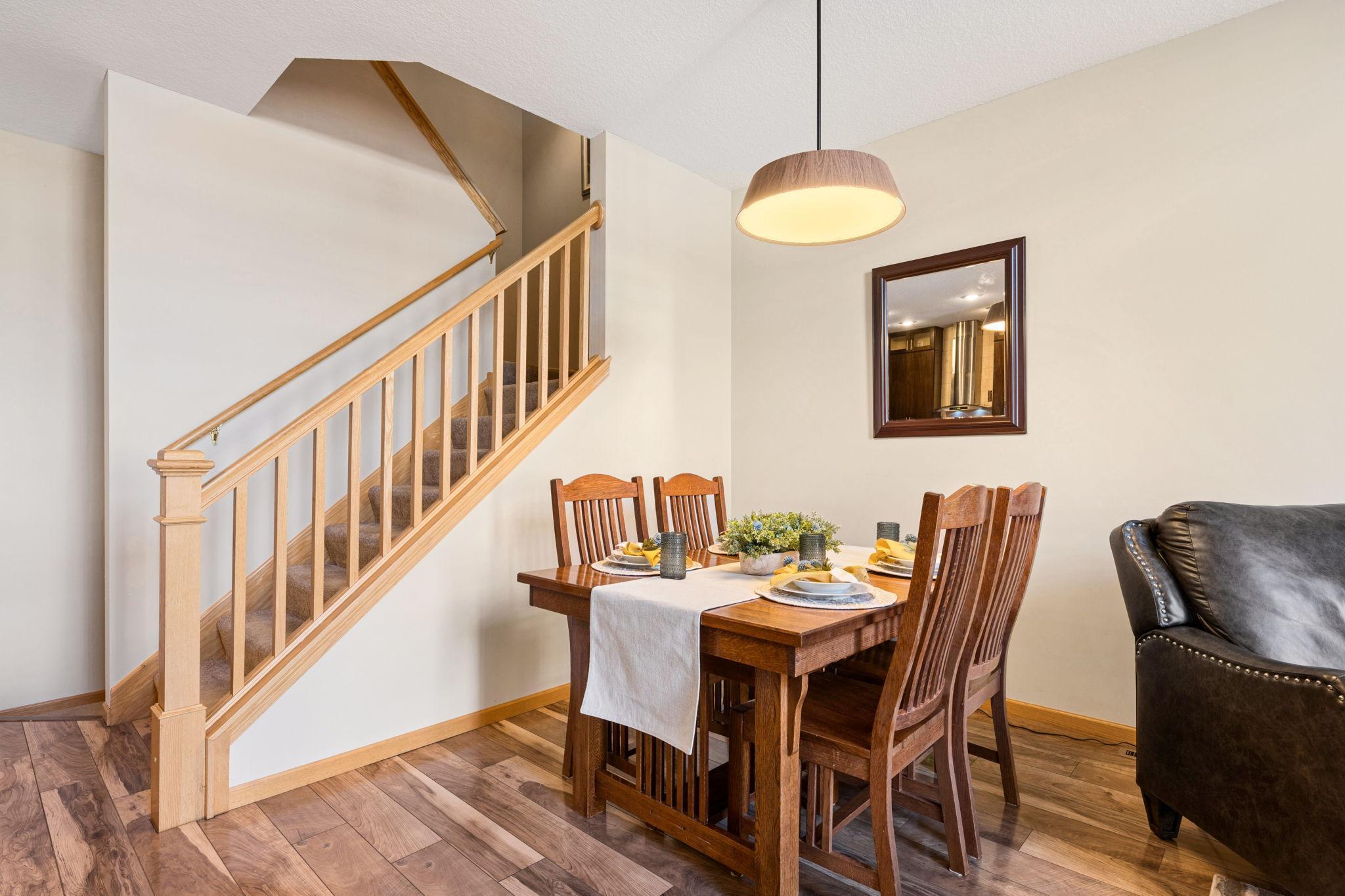 Dining area with warm finishes and easy access to the upper level. Open design keeps the space connected yet defined.