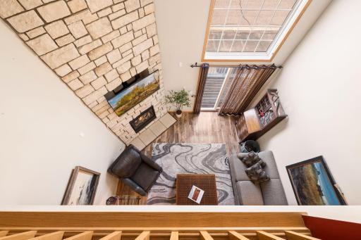 A stunning open-to-below design brings in natural light and highlights the floor-to-ceiling stone fireplaceâcreating a true focal point from every level.