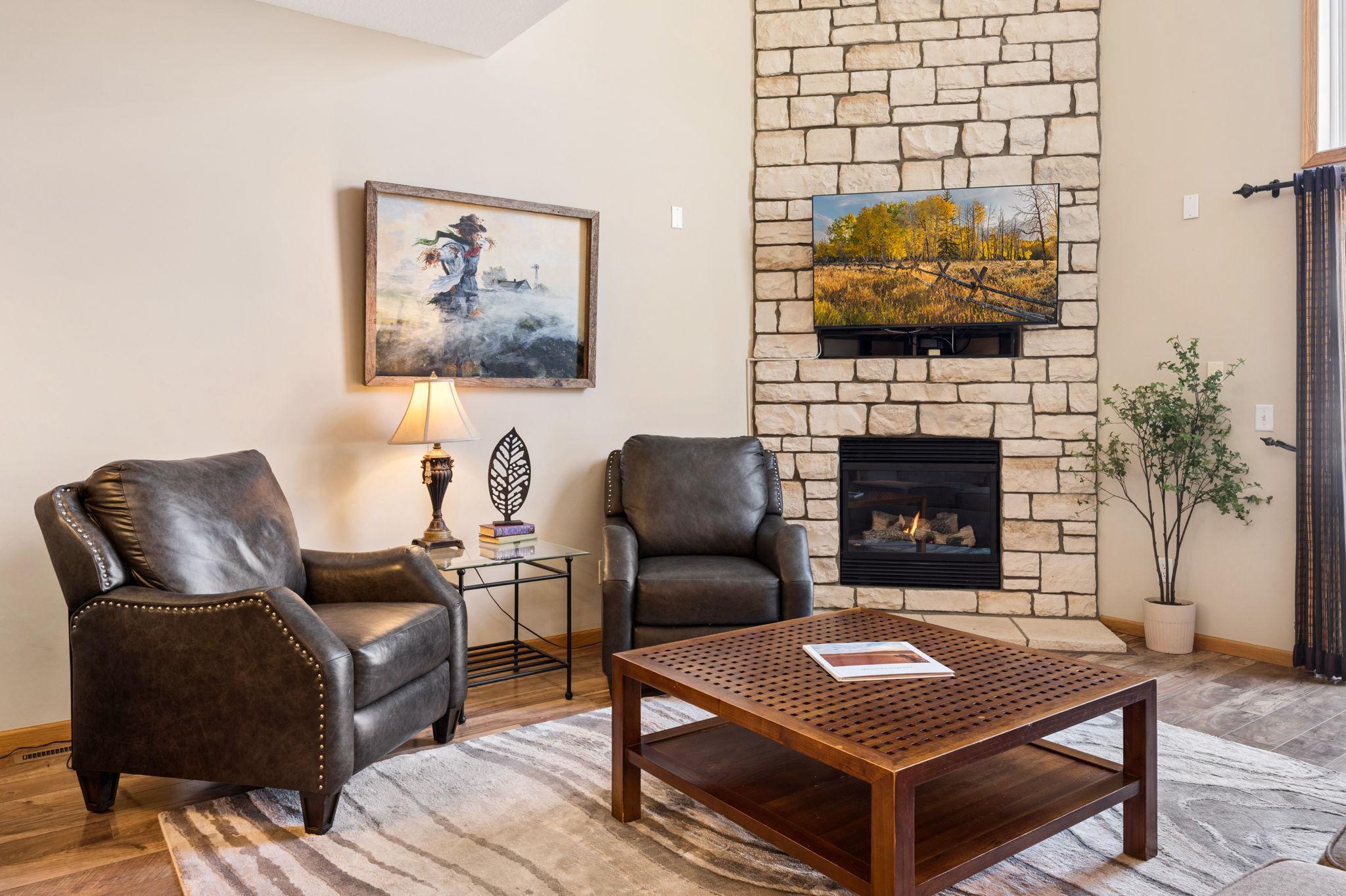 Floor-to-ceiling stone fireplace creates a warm and striking focal point. Perfect space to relax and unwind.