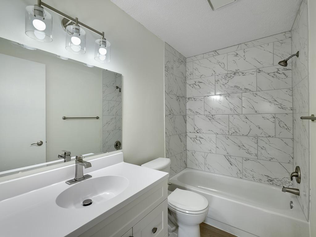 Relax in the updated bathroom with new flooring, vanity, and tile.