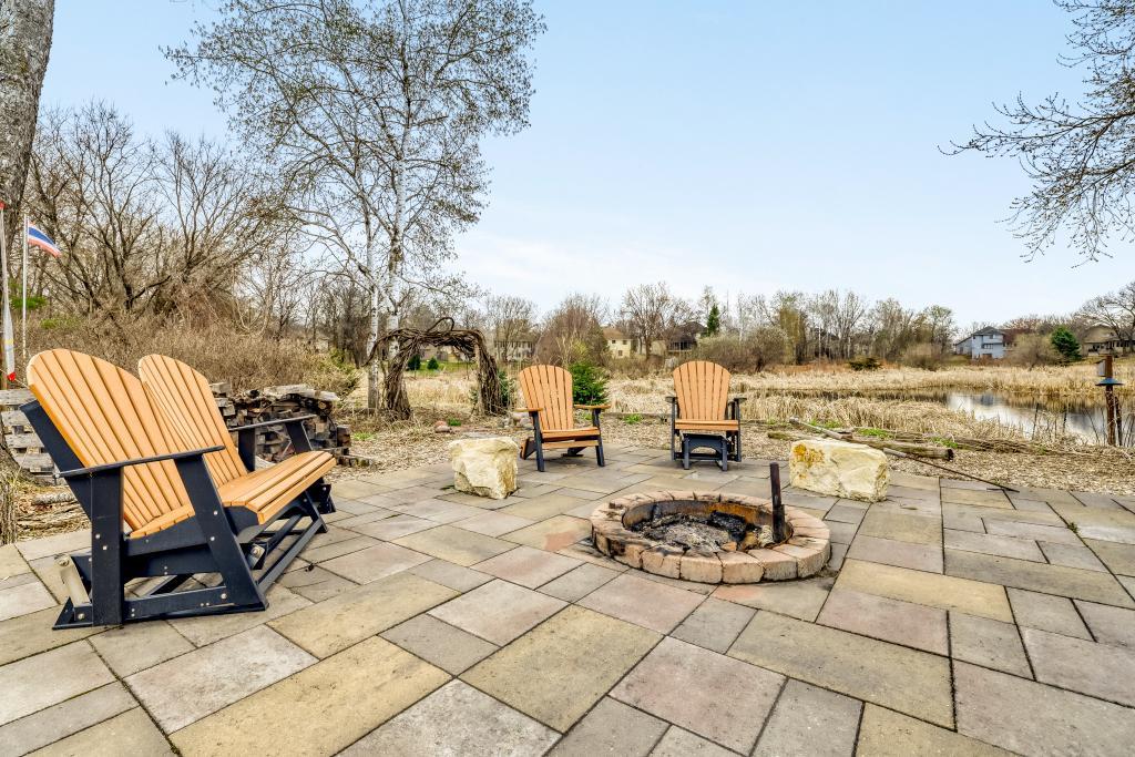 Patio area with fire pit near pond