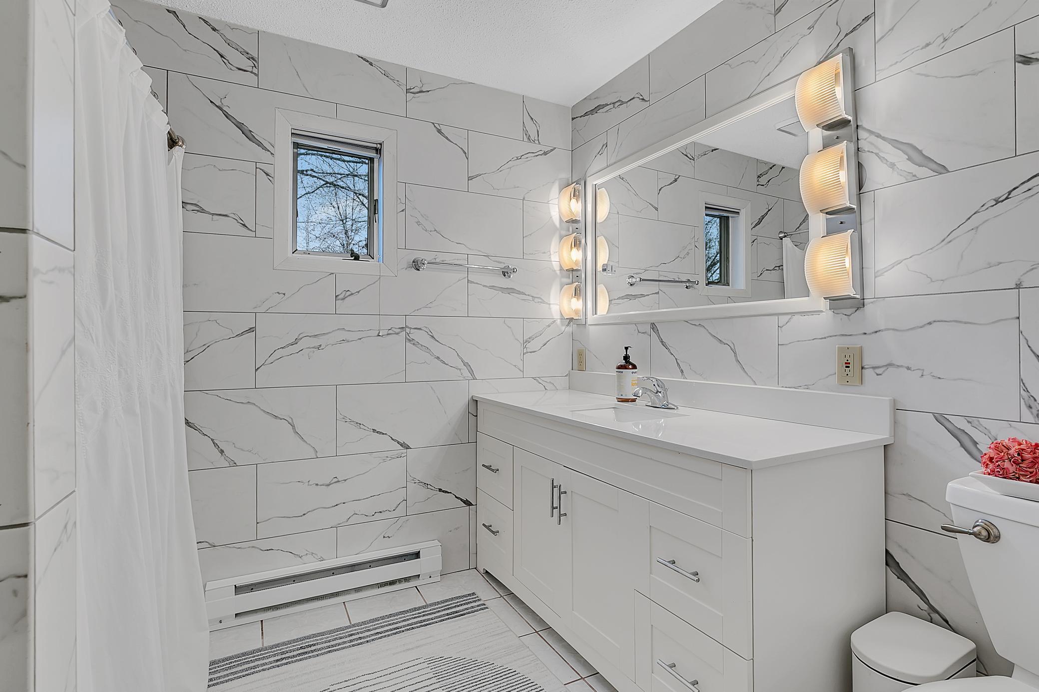 The primary bathroom is beautiful. The porceliun tile surround the bathroom. There is a whirlpool tub and a linen closet.linen closet too.