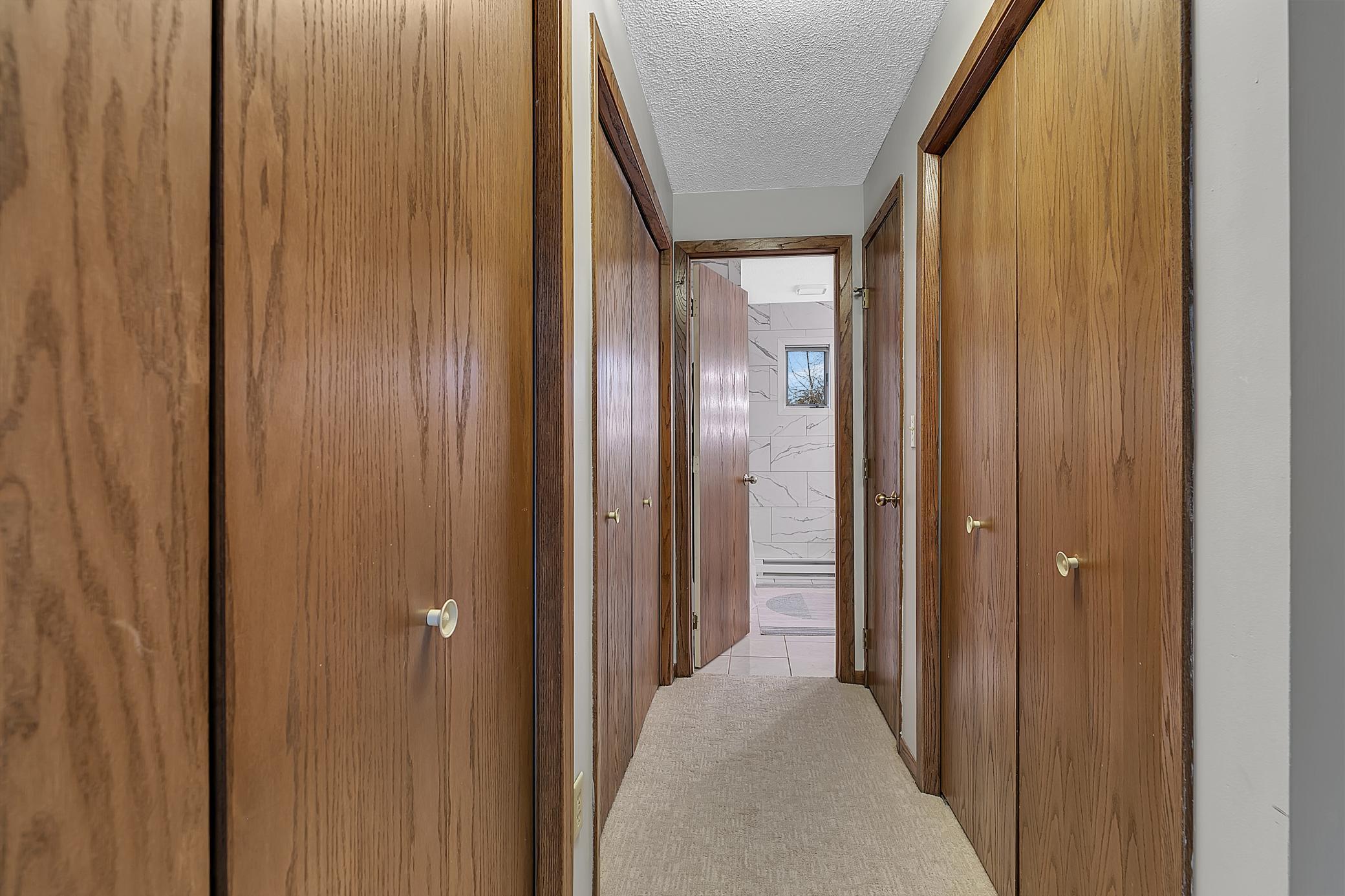 The hallway between the primary bedroom and bath. There is so much storage space.