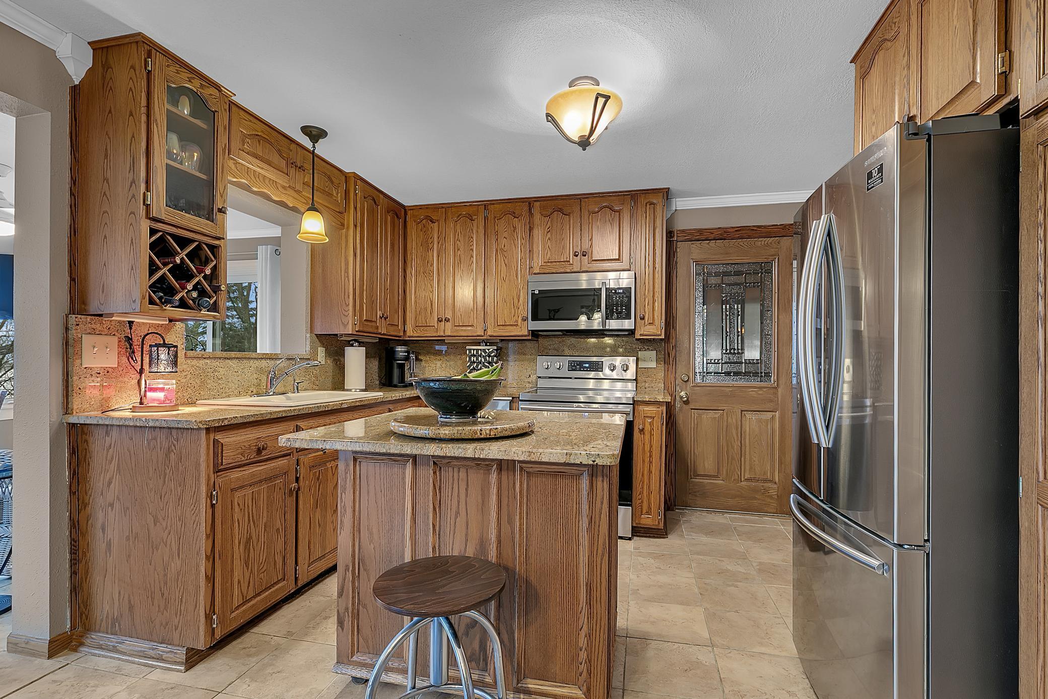 The kitchen is perfect. There is a moveable island, granite counter, stainless appliances, and tiled backsplash.