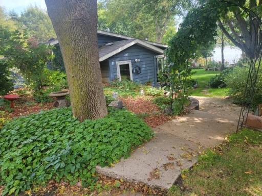 There is a charming walkway leading to the entrance of the home. Both sides are filled with beautiful flowers and greenery.