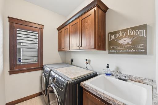 Main level laundry with custom cabinets and a tub sink.
